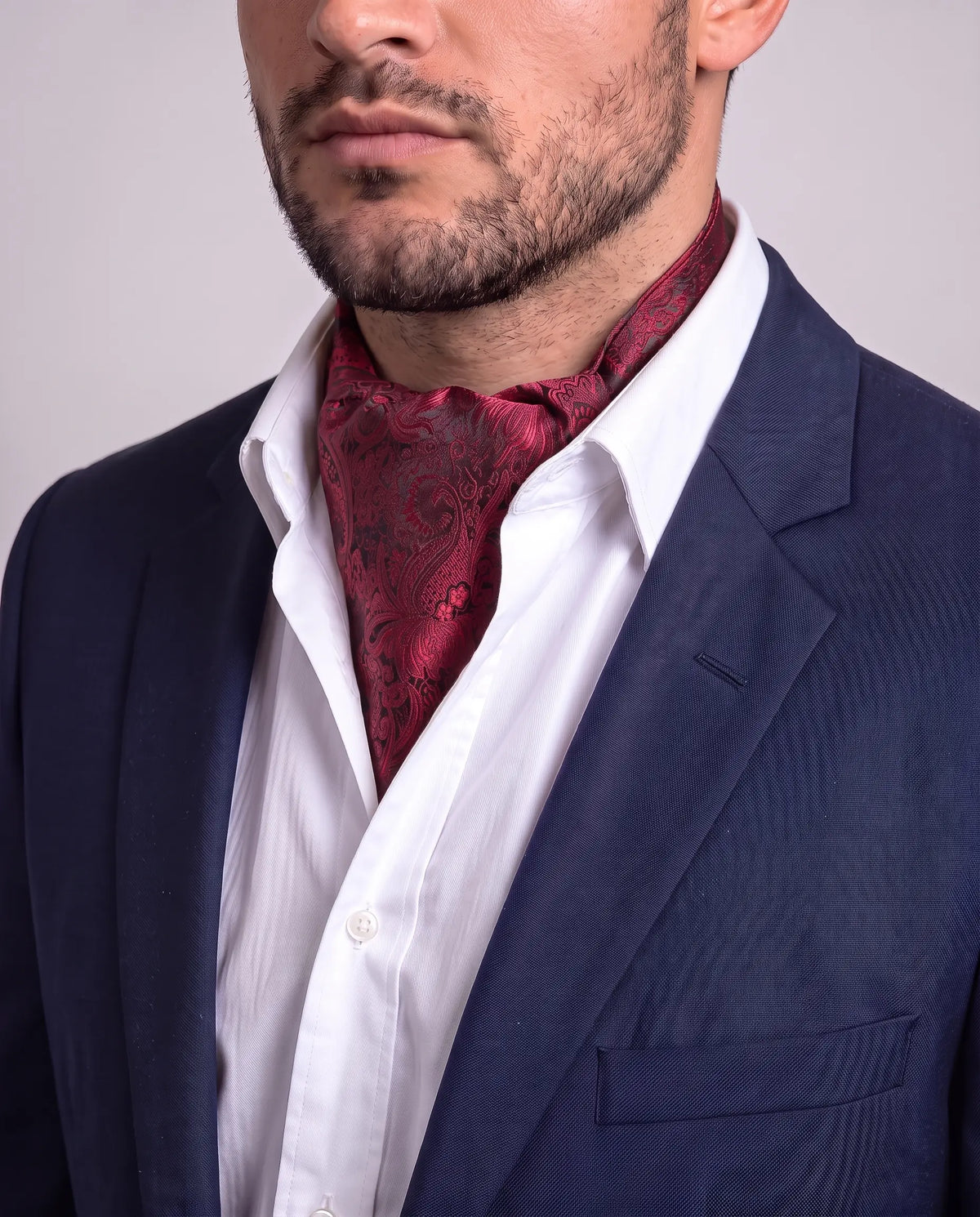 Mann i mørk dressjakke og hvit skjorte med rød floral ascot, modell Shanghai